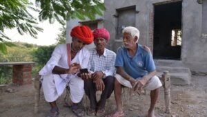 three village people watching smartphone