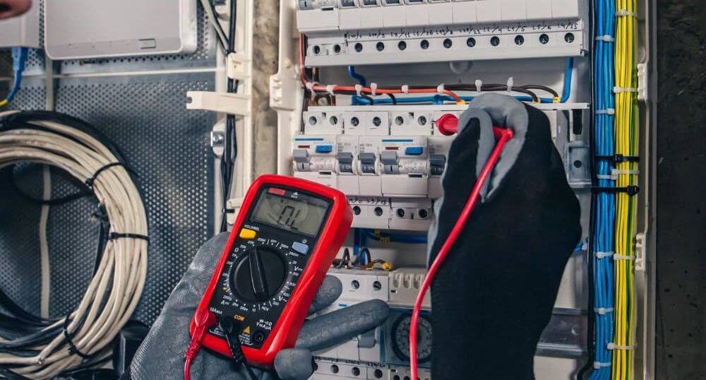 image showsMan an electrical technician working in a switchboard